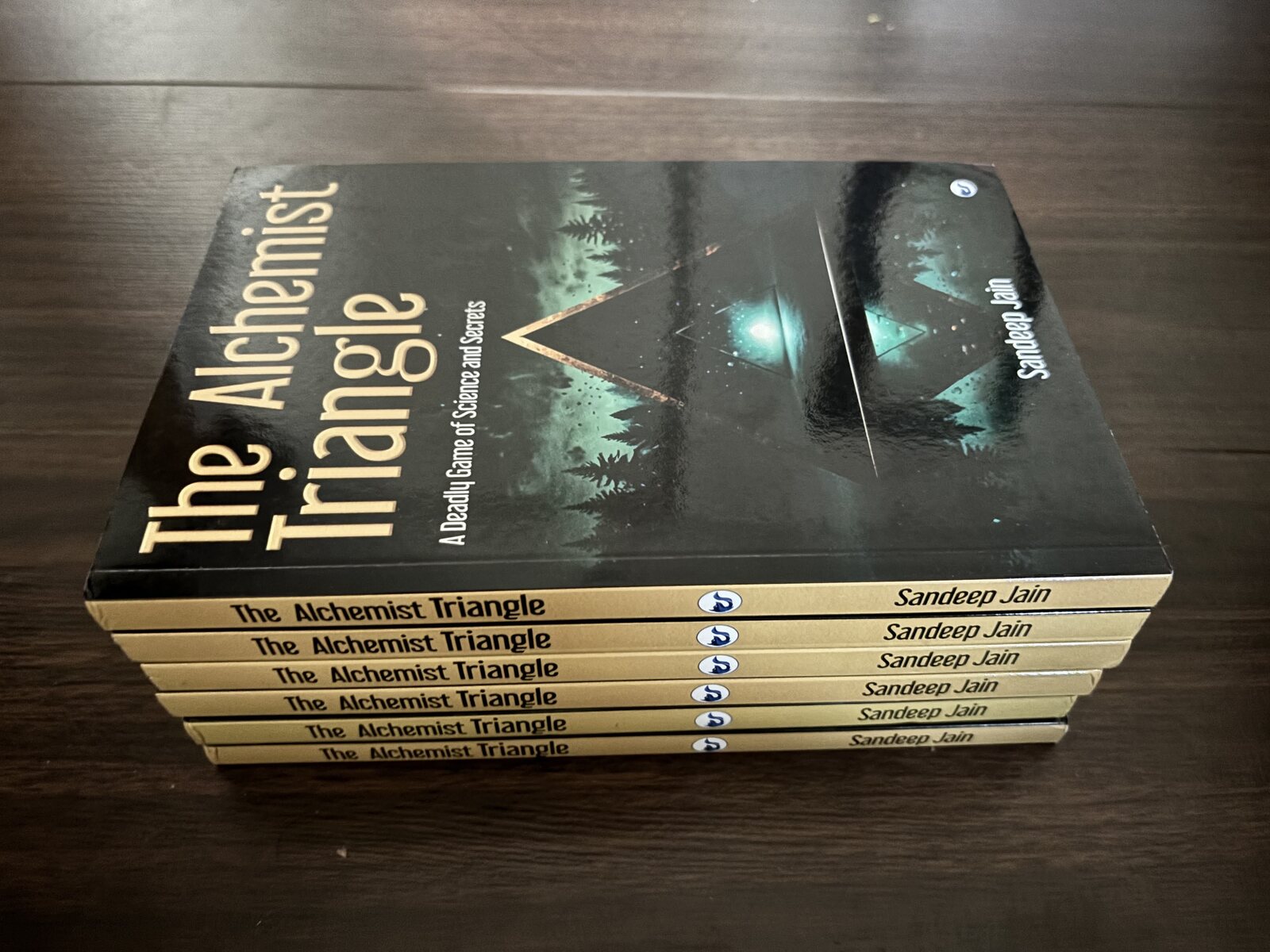Stack of The Alchemist Triangle paperbacks